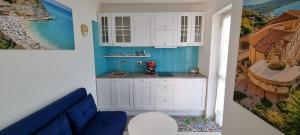 a kitchen with white cabinets and a blue wall at MAGIK hill in Pizzo