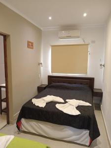 a bedroom with a bed with two white towels on it at DEL SOL APART TERMAL I in Termas de Río Hondo