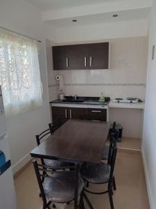 Il comprend une cuisine avec une table et des chaises en bois. dans l'établissement DEL SOL APART TERMAL I, à Termas de Río Hondo