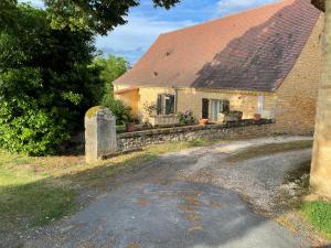 Stary kamienny kościół z krzyżem przed nim w obiekcie Holidayhome for 6 persons at Ferme la Geneste w mieście Coux-et-Bigaroque