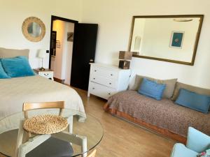 1 dormitorio con cama, sofá y espejo en Studio phare de Biarritz Résidence Régina Golf, en Biarritz