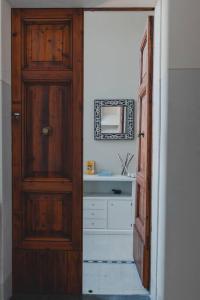 ein Badezimmer mit einer Holztür und einem Waschbecken in der Unterkunft [Duomo - City Center] Appartamento elegante con suite in Ravenna
