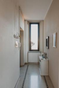 einen Flur mit einem Bad mit einem Waschbecken und einem Fenster in der Unterkunft [Duomo - City Center] Appartamento elegante con suite in Ravenna