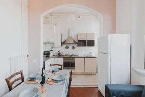 eine Küche mit einem Tisch und einem weißen Kühlschrank in der Unterkunft [Duomo - City Center] Appartamento elegante con suite in Ravenna