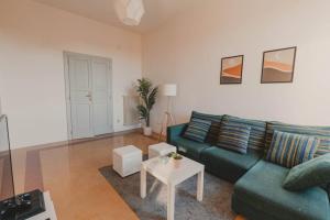 ein Wohnzimmer mit einem grünen Sofa und einem Tisch in der Unterkunft [Duomo - City Center] Appartamento elegante con suite in Ravenna