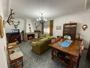 a living room with a couch and a table at CHALET con ENCANTO en SIERRA CORDOBESA. WIFI in Cerro Muriano