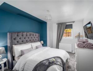 una camera con un grande letto con una parete blu di The School House a Broughty Ferry