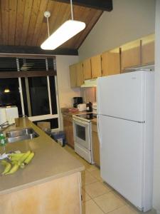 a kitchen with a white refrigerator and a sink at The Cliffs Club at Princeville in Princeville