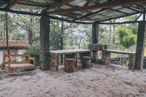 a stone pavilion with two benches and a table at Casa de Campo Villa Carolina en Zambrano in Zambrano
