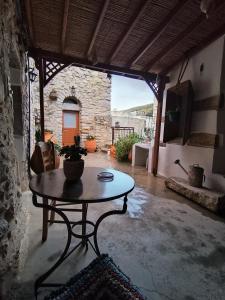 eine Terrasse mit einem Tisch in einem Zimmer mit einem Fenster in der Unterkunft ΜΕΣΤΑ - ΠΛΑΤΕΙΑ in Mestá