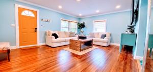 a living room with blue walls and a wooden floor at The Beachy Bungalow w/King Bed, near Dtwn & Beach in St. Petersburg