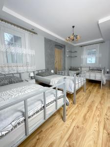 a bedroom with three bunk beds and wooden floors at Dom nad potokiem Opawa, na wyłączność, Karpacz, Opawa in Opawa