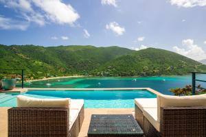 a swimming pool with a view of the water and mountains at Jost Van Dyke, BVI 3 Bedroom Villa with Caribbean Views & Pool in Jost Van Dyke