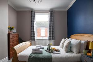 um quarto com uma cama com paredes azuis e uma janela em The Elderton, Newbiggin By The Sea, Northumberland em Newbiggin-by-the-Sea