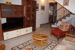 sala de estar con TV y sofá en Casa Vacanze “Dream House” en Scano Montiferro