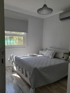 a white bedroom with a large bed and a window at Casa Quinta Las Casuarinas in Mercedes