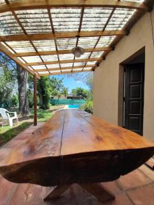 a wooden table with a large wooden boat on a patio at Casa Quinta Las Casuarinas in Mercedes