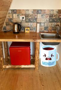 - un comptoir de cuisine avec un évier et une tasse de café dans l'établissement Horezu Cozy Cabin, 