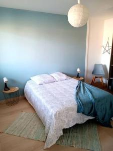 - une chambre dotée d'un lit avec un mur bleu dans l'établissement LE COSY plein centre avec terrasse, à Meximieux