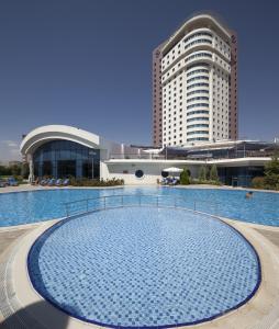 a large swimming pool in front of a large building at Dedeman Konya Hotel Convention Center in Konya