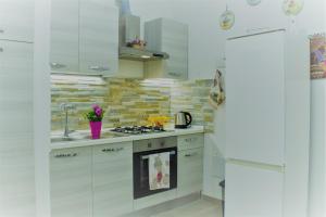 巴勒摩的住宿－Casa Vacanza Al Massimo，厨房配有白色橱柜和炉灶烤箱。