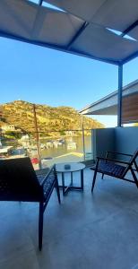 a room with a table and a bench and a view of a harbor at Amimaya Apartments in Emporeios