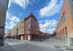 an empty street with a building on the corner at Piscina en Centro de Terrassa in Terrassa