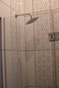 a shower with a glass door in a bathroom at Park Central Apartment in Pretoria