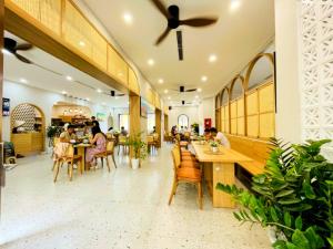 restauracja z ludźmi siedzącymi przy stolikach w obiekcie Rova Hotel Phú Quốc w Duong Dong