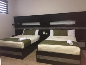 Dos camas en una habitación de hotel con dos en Hotel Majestic 2 by Bustamante Hotels, en Cuenca