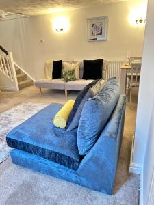 a blue couch sitting in a living room at Mount Yard - Stylish Cottage - Close to Alton Towers - Water World -Stoke-on-Trent Sleeps 5 in Totmonslow