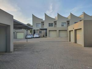 a large building with two garages and a parking lot at Park Central Apartment in Pretoria