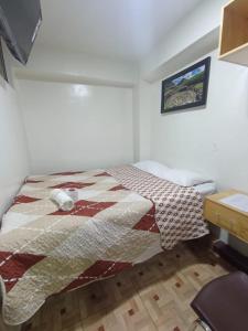 1 dormitorio con 1 cama con edredón en Hostal Estrellas, en Huaraz
