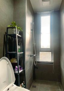 baño con ducha, aseo y ventana en 慢時光中興時尚青公寓, en Nantou City