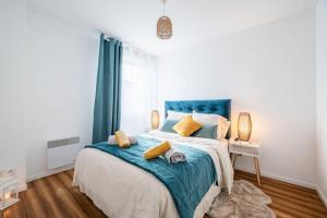 ein Schlafzimmer mit einem großen Bett mit einer blauen Decke in der Unterkunft Le Nid Douillet T2, Wifi, Parking privé gratuit in Lille
