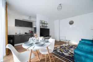 a kitchen and a living room with a table and chairs at Le Nid Douillet T2, Wifi, Parking privé gratuit in Lille