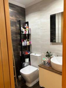 a bathroom with a white toilet and a sink at Residencial Playa Poniente 66 de Gijón in Gijón +25 photos