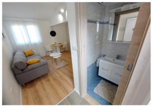 sala de estar con sofá y lavabo y baño en Apartments Fantasia, en Pula