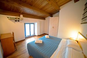 1 dormitorio con cama azul y techo de madera en Agriturismo Campo Rosso, en Civitella di Romagna