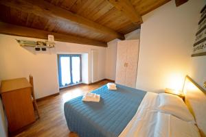 a bedroom with a blue bed with a wooden ceiling at Agriturismo Campo Rosso in Civitella di Romagna