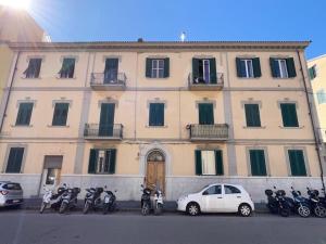 ein großes Gebäude mit davor geparkt in der Unterkunft Kia Orana Guesthouse in Livorno