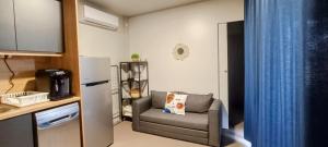 a small living room with a couch and a refrigerator at SAK Mobile Home Pirovac in Pirovac