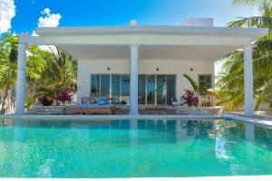 a swimming pool in front of a villa at Telchac Beach House in Telchac Puerto