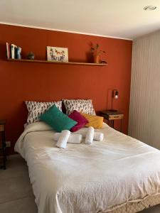 a bedroom with a large white bed with colorful pillows at Bungalow Pai-Pay 2 in San Carlos de Bariloche