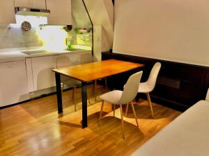 a kitchen with a wooden table and two chairs at Edificio El Moderno, Vigo 1.902 in Vigo