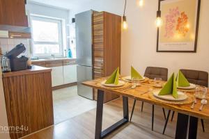 a dining table with green napkins on it in a kitchen at Business-Apartment in Amberg