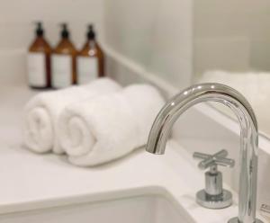 a bathroom sink with a faucet and towels on a counter at Soar Luxury Studio en el centro de Salta in Salta +20 photos