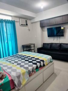 a bedroom with a bed and a couch at Cubao Manhattanheights U31N TB, Studio Unit in Manila