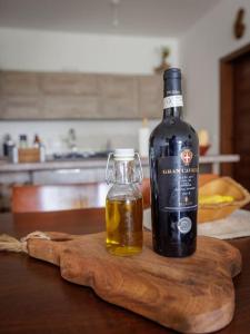 a bottle of wine and a jar of honey on a cutting board at Luxury en-suite Double. Beach-house with Sea Views in Mellieħa
