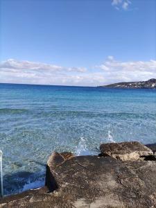 a body of water with rocks and the ocean at Luxury en-suite Double. Beach-house with Sea Views in Mellieħa